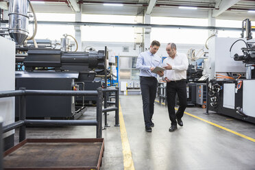 Two men with tablet talking in factory shop floor - DIGF01887