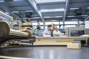 Two men at cenveyor belt in factory shop floor - DIGF01900