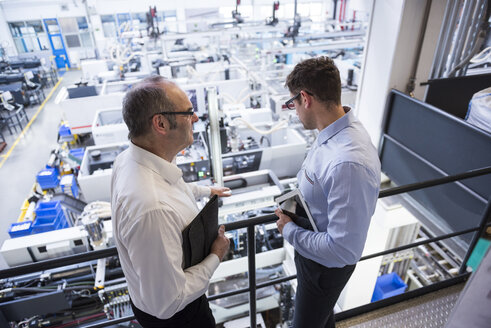 Two men talking in factory shop floor - DIGF01918