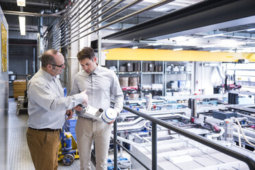 Two men in factory shop floor talking about product - DIGF01955