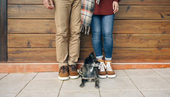 Tiefschnitt eines Paares mit Hund vor einer Holzwand stehend - DAPF00711