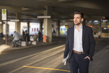 Portrait of young businessman waiting at bus terminal - DIGF02002