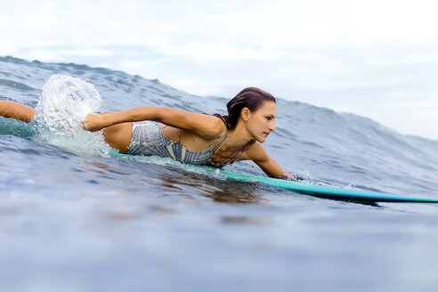 Girl surfing in ocean - KNTF00824