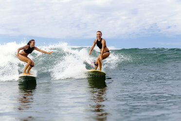 Zwei Mädchen beim Surfen im Meer - KNTF00825