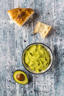 Schale mit Avocado-Hummus, einer halben Avocado und Fladenbrot - SARF03306