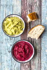 Bowls of beetroot hummus and avocado hummus with flat bread - SARF03310