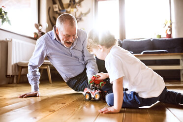 Großvater und Enkelsohn spielen zu Hause mit Spielzeug - HAPF01499