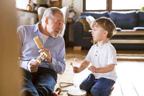 Großvater und Enkel musizieren zu Hause, lizenzfreies Stockfoto