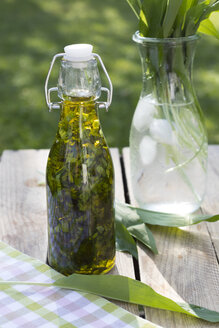 Bügelverschlussflasche mit gehacktem Bärlauch in Olivenöl - YFF00662