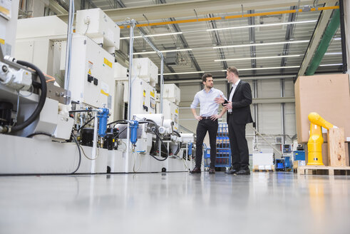 Two men talking in factory shop floor - DIGF02023