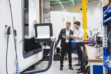 Two men in factory shop floor talking about a product - DIGF02025