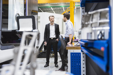 Two men talking in factory shop floor - DIGF02029