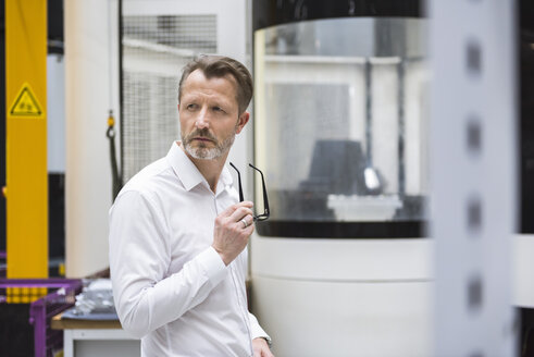 Pensive businessman in factory shop floor - DIGF02035