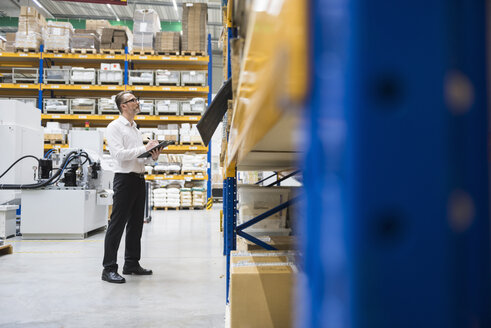 Man in storehouse taking notes - DIGF02037