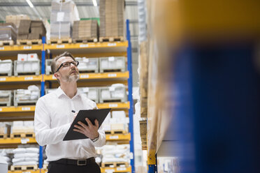 Man in storehouse taking notes - DIGF02039