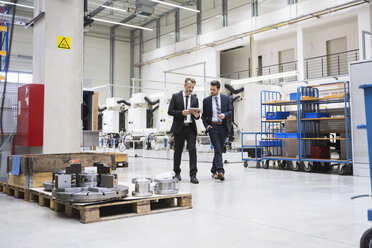 Zwei Geschäftsleute mit Tablet zu Fuß in der Fabrik Shop Floor - DIGF02045