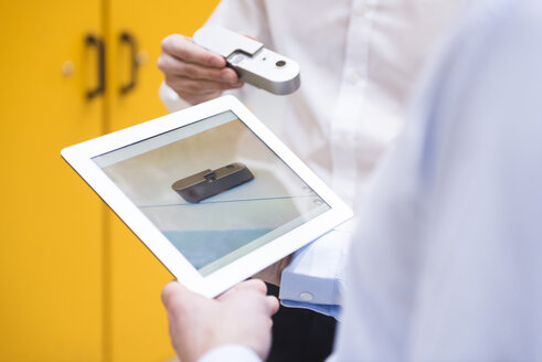 Close-up of two men with tablet and product in factory - DIGF02077