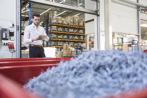 Man in factory shop floor using tablet stock photo