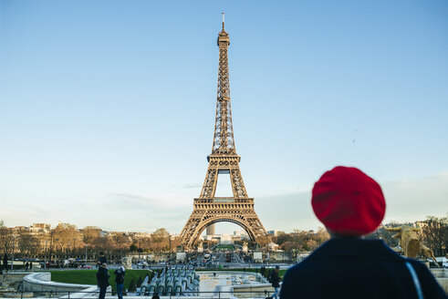 Frankreich, Paris, Blick auf den Eiffelturm mit Rückenansicht einer jungen Frau im Vordergrund - KIJF01387