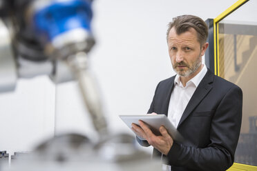 Erwachsener Geschäftsmann steuert Industrieroboter mit digitalem Tablet - DIGF02112