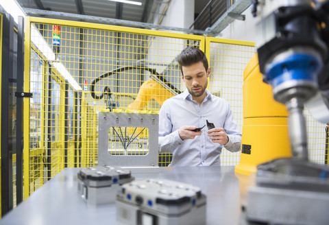 Young businessman checking automated production in factory stock photo