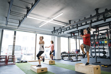 Eine Gruppe fitter Senioren trainiert mit Holzkisten im Fitnessstudio - HAPF01512