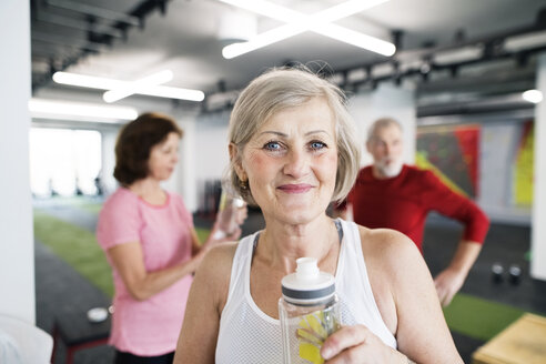 Gruppe von fitten Senioren im Fitnessstudio, die eine Pause machen und eine Erfrischung trinken - HAPF01514