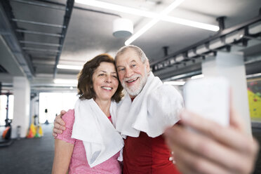 Ein fittes älteres Paar macht Selfies mit dem Smartphone im Fitnessstudio - HAPF01517