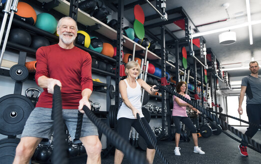 Senioren im Fitnessstudio trainieren mit Kampfseilen - HAPF01519