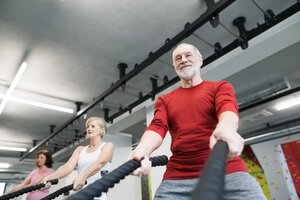 Senioren im Fitnessstudio trainieren mit Kampfseilen - HAPF01521