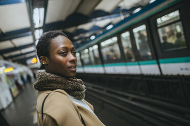 Frankreich, Paris, Porträt einer jungen Frau auf dem Bahnsteig einer U-Bahn-Station - KIJF01404