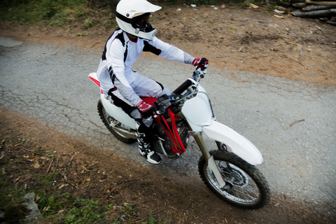 Italien, Motocross-Biker beim Schleifen im toskanischen Wald, lizenzfreies Stockfoto