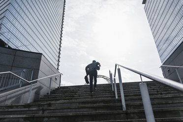 Businessman running upstairs - UUF10380