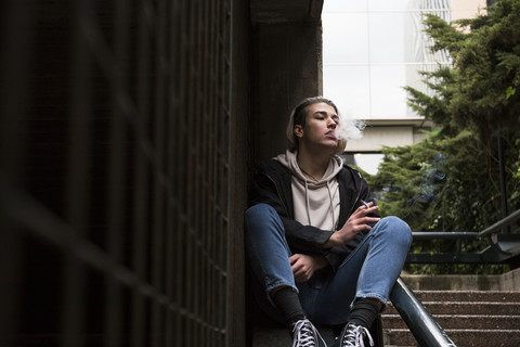 Junger Mann raucht Zigarette, lizenzfreies Stockfoto