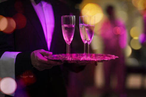 Kellner mit Tablett serviert Champagnergläser auf einer Party - ZEF13565