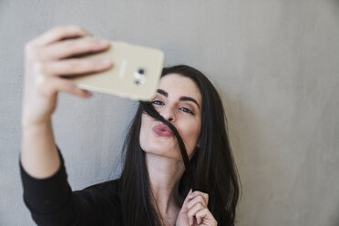 Junge Frau schmollt und macht ein Selfie - FMKF03976