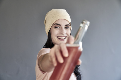 Porträt einer lächelnden jungen Frau mit Flasche, lizenzfreies Stockfoto