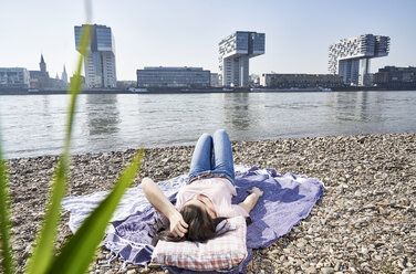 Deutschland, Köln, junge Frau entspannt am Rhein - FMKF04047