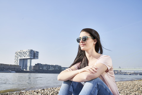 Germany, Cologne, young woman relaxing at River Rhine stock photo