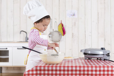 Little girl preparing waffles, wearing chef's hat - DRF01725