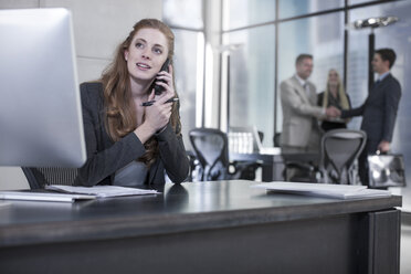 Woman on the phone at office desk - ZEF13596
