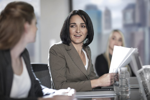 Zwei Frauen im Gespräch im Sitzungssaal, lizenzfreies Stockfoto