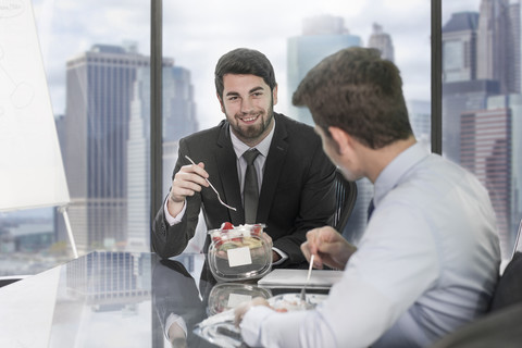 Kollegen bei der Mittagspause im Büro, lizenzfreies Stockfoto