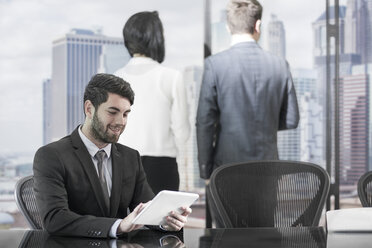 Smiling businessman using tablet in boardroom - ZEF13643