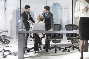 Group of businesspeople with laptop discussing in office - ZEF13644