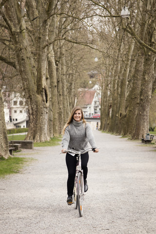 Junge Frau fährt Fahrrad, lizenzfreies Stockfoto