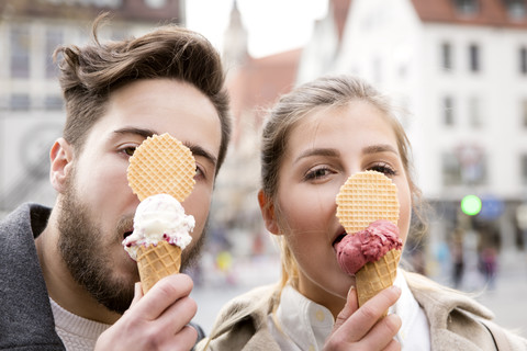 Lustiges Porträt eines jungen Paares beim Eisessen, lizenzfreies Stockfoto
