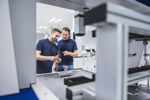 Two men at a machine in testing instrument room - DIGF02133