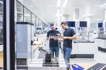 Two men in testing instrument room talking about product - DIGF02151