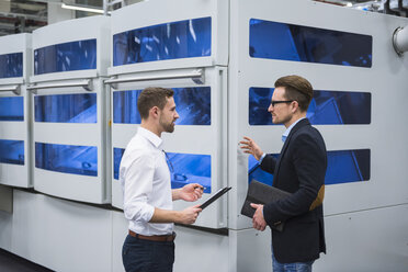 Two men talking in factory shop floor - DIGF02155